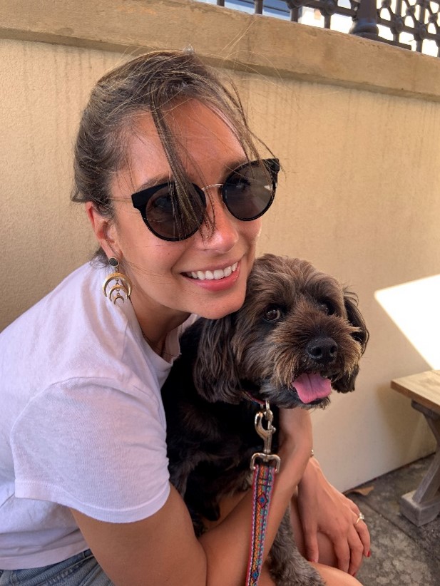 Woman with sunglasses on and brown dog